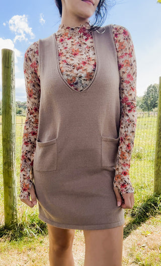 Taupe knit sleeveless mini dress layered over a sheer floral mock neck top with warm autumn blooms.